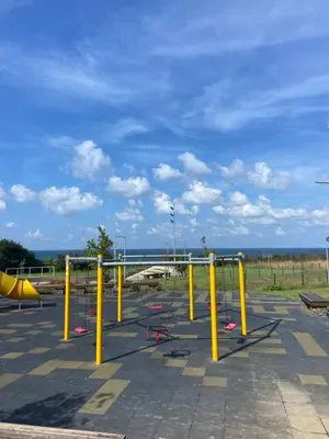 an empty playground with yellow poles in a parking lot at Порт Лозенец Морска Гледка - Port Lozenets Sea View in Lozenets