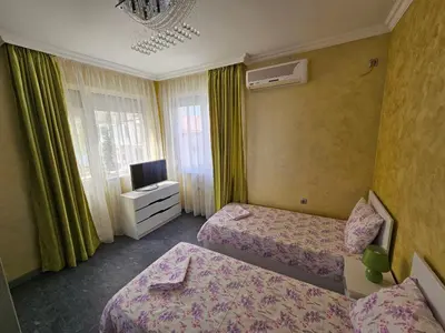 a hotel room with two beds and a television at Апартамент Елинор in Pomorie