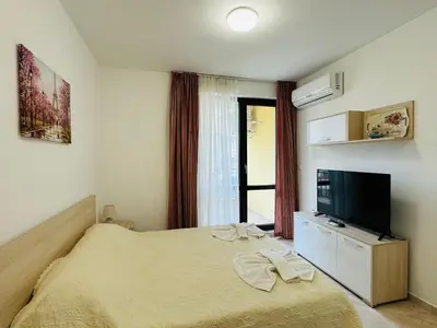 a bedroom with a bed and a flat screen tv at HORIZON 3 'В' Studio Sveti Vlas in Sveti Vlas