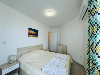 a small bedroom with a bed with white sheets at HORIZON 2 'В' Apartment Sveti Vlas in Sveti Vlas