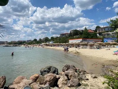 people on a beach with rocks in the water at HORIZON 2 'В' Apartment Sveti Vlas in Sveti Vlas