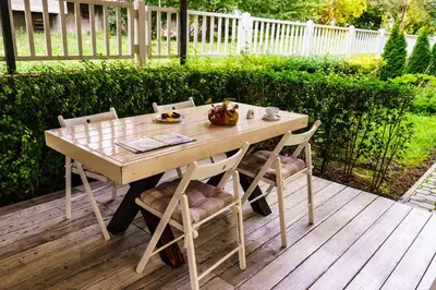 a wooden table and chairs on a wooden deck at Milano Hotel in Burgas City
