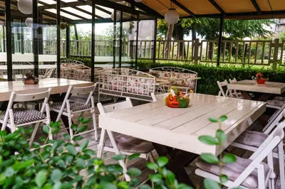 a group of tables and chairs in a garden at Milano Hotel in Burgas City