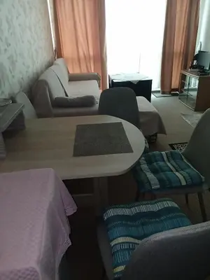 a living room with a table and chairs at Клара in Burgas City