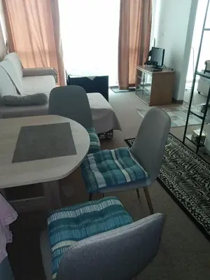 a living room with chairs and a table and a bed at Клара in Burgas City