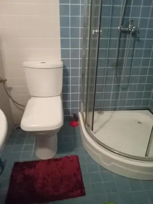 a bathroom with a white toilet and a shower at Клара in Burgas City