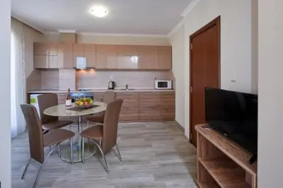a kitchen with a table and chairs and a television at Bendita House in Pomorie
