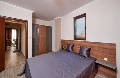 a bedroom with a large bed with a wooden headboard at Bendita House in Pomorie