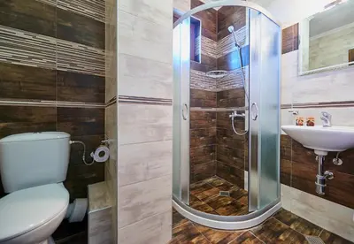 a bathroom with a shower and a toilet and a sink at Bendita House in Pomorie