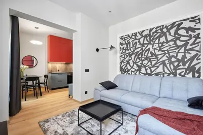 a living room with a couch and a black and white wall at Sea Moreto Apartment 2 in Burgas City