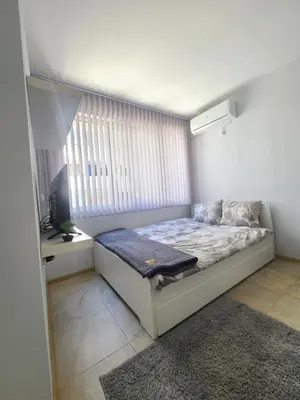 a small bedroom with a bed and a window at Downtown Apartment Varna in Varna City