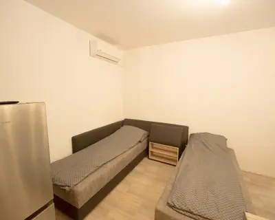 a small room with two beds and a refrigerator at Aleks Top Center 2- Free parking in Burgas City