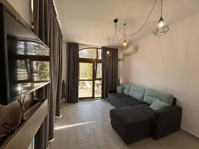 a living room with a couch and a tv at Studio/free yoga&aqua aerobic in Sunny Beach