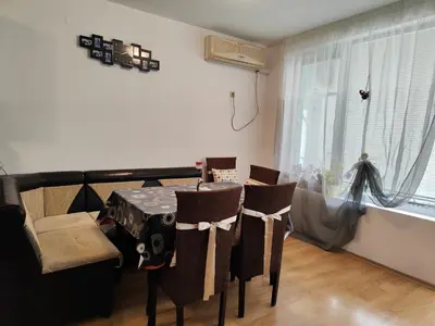a dining room with a table and chairs and a window at Nev in Burgas City