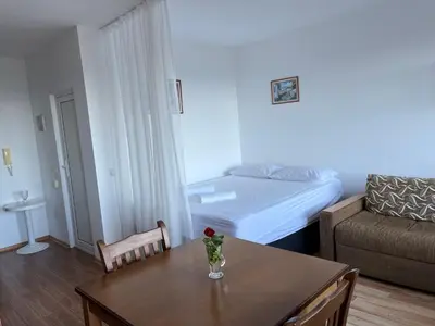 a small living room with a table and a bed at Summer Rose Studio by the Sea in Byala