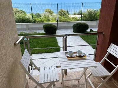 a table and two chairs on a balcony at Summer Rose Studio by the Sea in Byala
