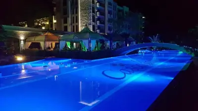 a swimming pool at night with blue lights at Coliber Apart Cascadas in Sunny Beach