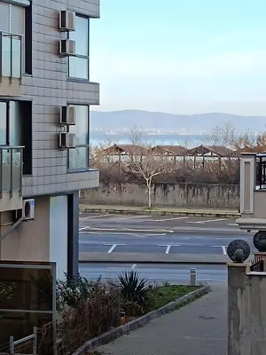 an empty parking lot next to a building at Pomorie Chaika Home in Pomorie