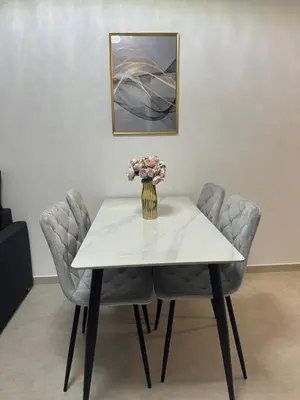 a table and chairs with a vase of flowers on it at Premium Ferienwohnung SWETI WLAS Polarstar Beach Luxury Apartment 150 m zum Strand Pool 3 Balkone Meeresblick Google TV bis zu 6 Personen in Sveti Vlas