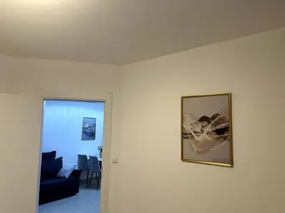 a living room with a couch and a picture on a wall at Premium Ferienwohnung SWETI WLAS Polarstar Beach Luxury Apartment 150 m zum Strand Pool 3 Balkone Meeresblick Google TV bis zu 6 Personen in Sveti Vlas