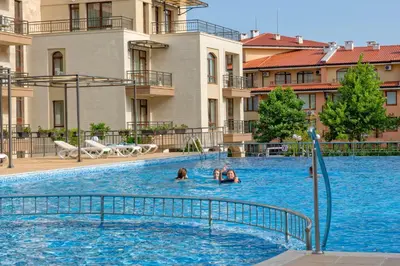 two people swimming in a swimming pool in a building at Sorrento Sole Mare Apartments in Sveti Vlas