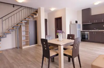 a dining room with a table and chairs and a staircase at Sorrento Sole Mare Apartments in Sveti Vlas