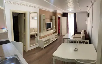 a living room with a kitchen and a living room with a television at Penthouse Happy Moments 4 in Sunny Beach