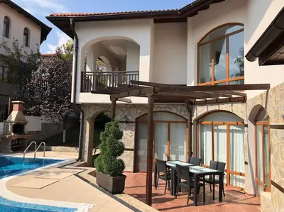 a house with a table and chairs next to a swimming pool at STUNNING VILLA with PRIVATE POOL in Kableshkovo