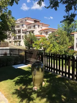 a vase sitting on the grass in front of a fence at STUNNING VILLA with PRIVATE POOL in Kableshkovo