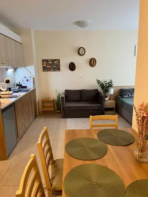 a kitchen and a living room with a table and chairs at Good Mood Studio in Green Life First Line in Sozopol