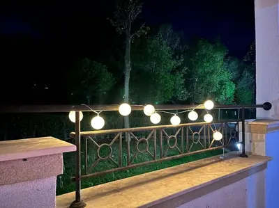 a string of lights on a fence at night at Good Mood Studio in Green Life First Line in Sozopol
