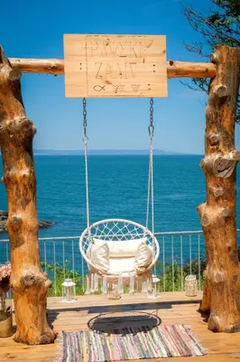 a swinging chair on a deck overlooking the ocean at PARADISE Bay Hotel in Sozopol