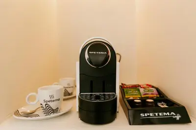 a coffee maker sitting on a table next to a cup at PARADISE Bay Hotel in Sozopol