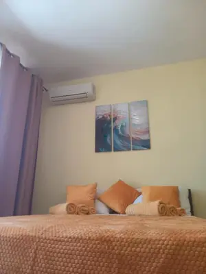 a bedroom with a bed with two paintings on the wall at One-room boutique at Sunrise All Suites in Obzor