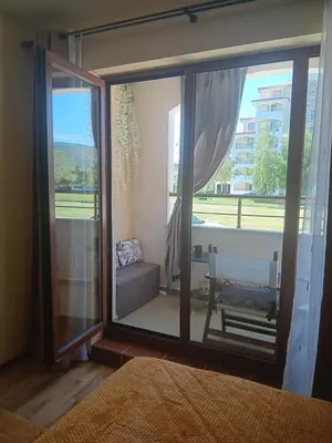 a bedroom with a large glass window with a couch at One-room boutique at Sunrise All Suites in Obzor