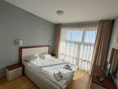a bedroom with a bed and a large window at Magic Dreams Apartments in Sveti Vlas