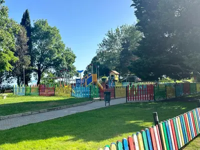 a playground in a park with a colorful fence at Seaside Apartment Nesebar in Nesebar