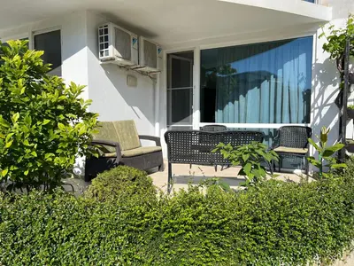 a patio with two chairs and a couch on a porch at Apartment with terrace in Spa Complex in Burgas City