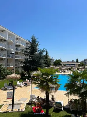 a resort with a pool and people laying on the lawn at Apartment with terrace in Spa Complex in Burgas City