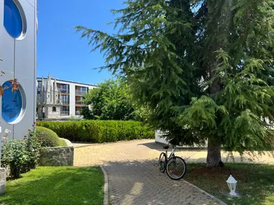 a bike parked next to a tree on a sidewalk at Apartment with terrace in Spa Complex in Burgas City
