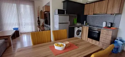 a kitchen with a table with a bowl of fruit on it at Reina Apart Flores Park in Sunny Beach