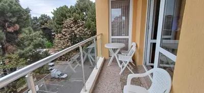 a balcony with two chairs and a table on a porch at Reina Apart Flores Park in Sunny Beach