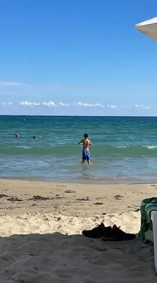 a man standing in the water at the beach at Peter Apartmanbulgaria-Crown Fort Noks in Sveti Vlas