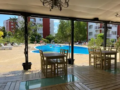 a patio with tables and chairs and a swimming pool at Peter Apartmanbulgaria-Imperial Fort Noks in Elenite