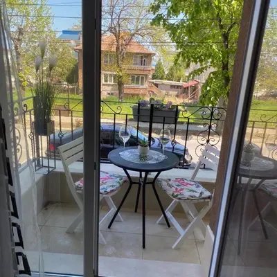 a patio with a table and chairs on a balcony at Апартамент за гости ДЕНИЦА in Obzor