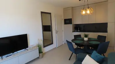 a living room with a table and chairs and a television at Polarstar Apartment Verona in Sveti Vlas