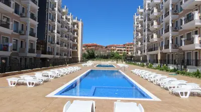 a swimming pool in the middle of a building with white lounge chairs at Polarstar Apartment Verona in Sveti Vlas