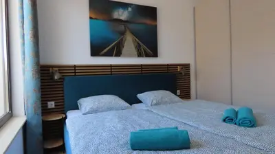 a bedroom with a blue bed with two blue pillows at Polarstar Apartment Verona in Sveti Vlas