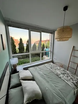 a bedroom with a bed and a large window at Black Sea Breeze Apartment No 3 in Byala