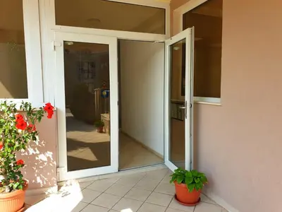 an open glass door of a house with potted plants at Black Sea Breeze Apartment No 3 in Byala